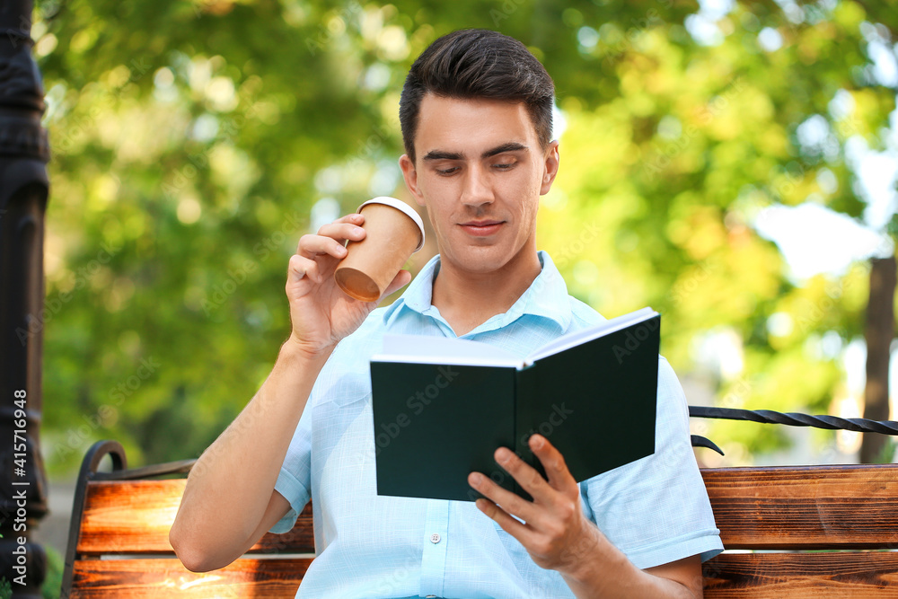 Young man reading book in park