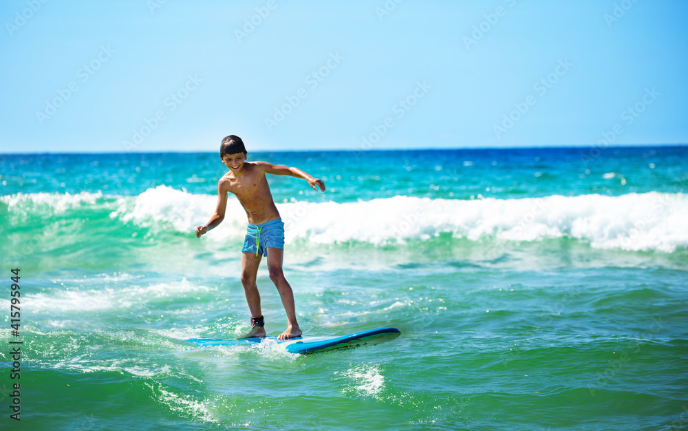 Happy boy ride surfboard on waves confidently surfing photo over sea