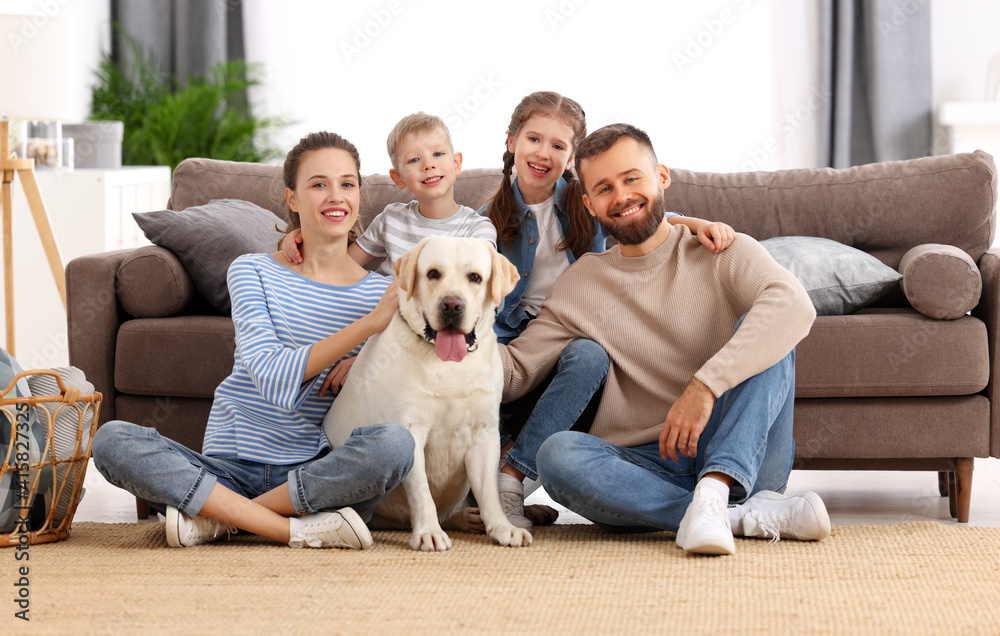 Happy idyllic family with kids and dog resting at home