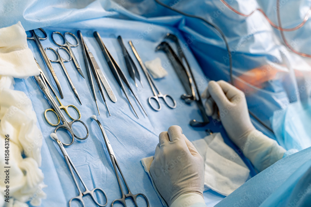 A table with surgical sterile instruments, scalpels and clamps. Details of the operating room, prepa