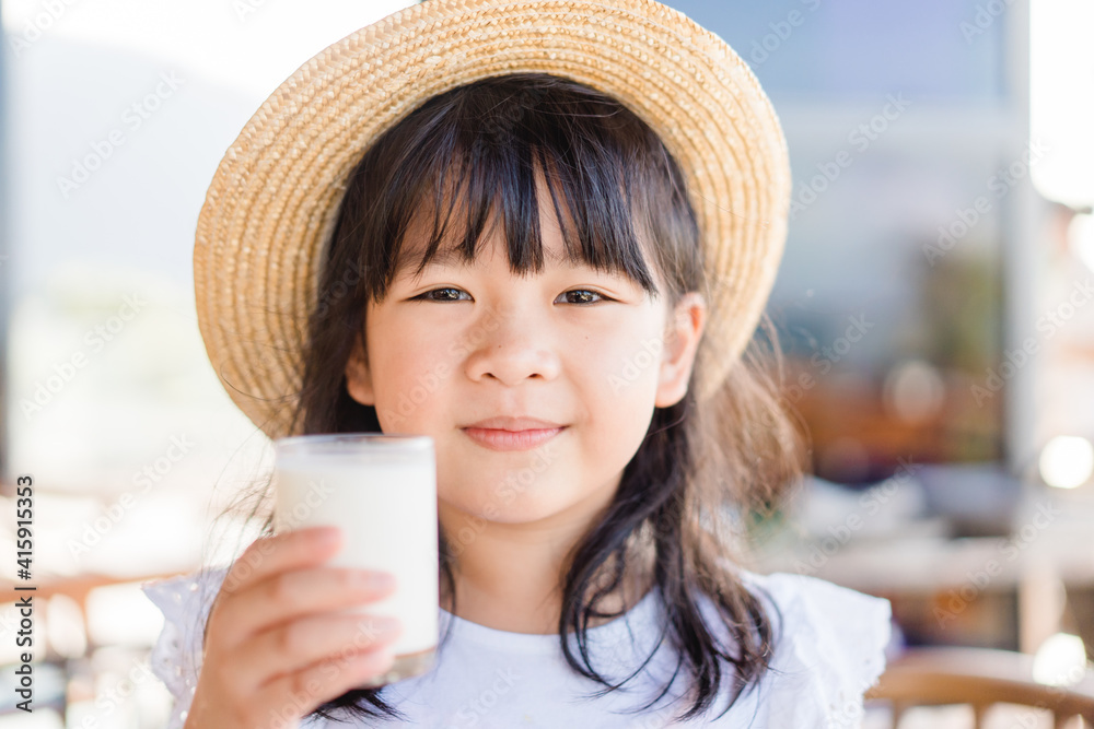 玻璃上的新鲜有机无乳糖牛奶。亚洲可爱的小女孩正在喝牛奶。来自m的钙维生素