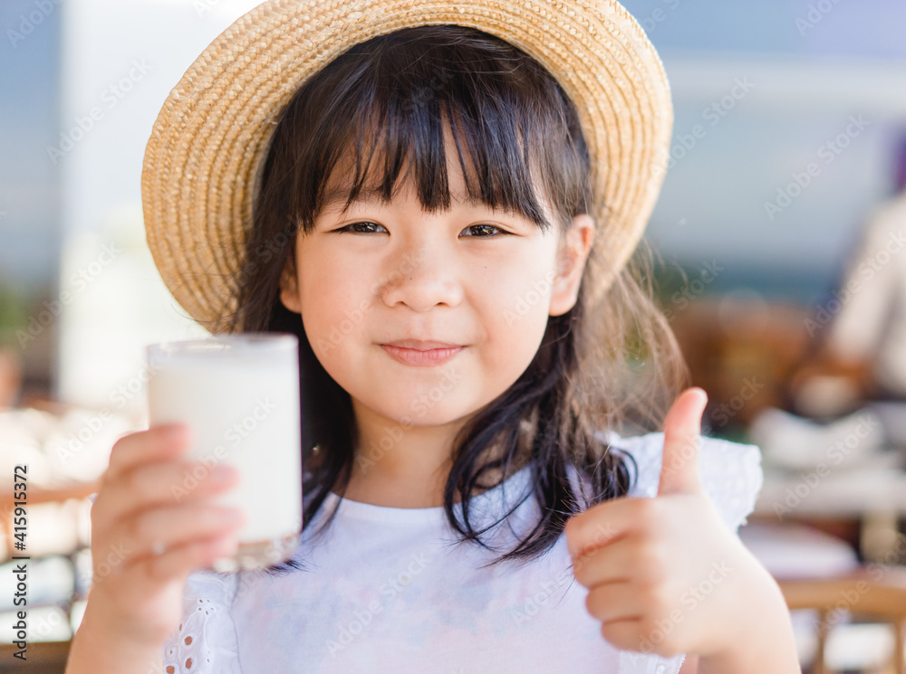 新鲜的有机无乳糖玻璃牛奶。亚洲可爱的小女孩喝牛奶。来自m的钙维生素