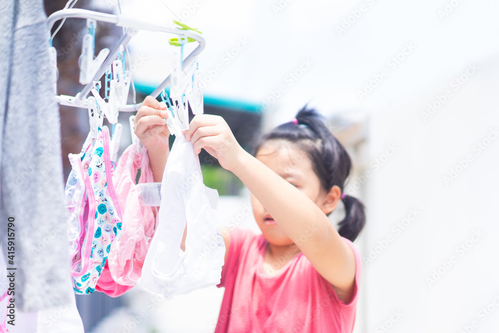 家里有保姆。夏天早上在家洗衣。亚洲女孩和她一起排队烘干衣服