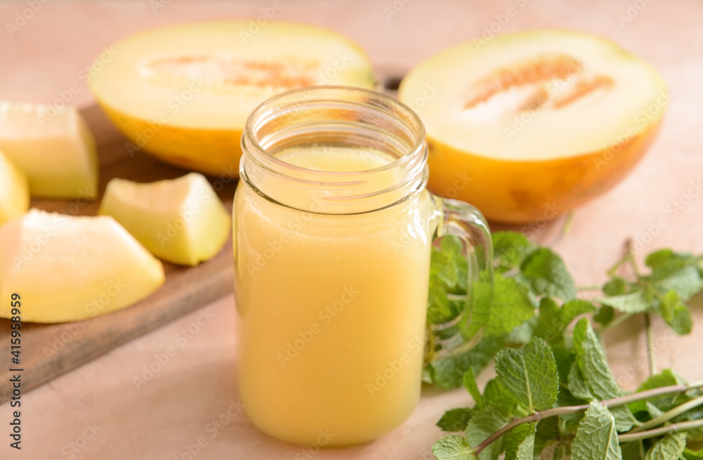 Mason jar with melon smoothie on color background