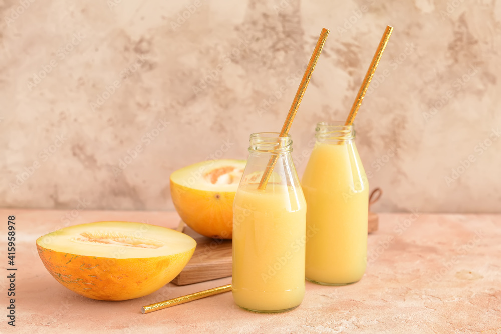 Bottles with melon smoothie on color background