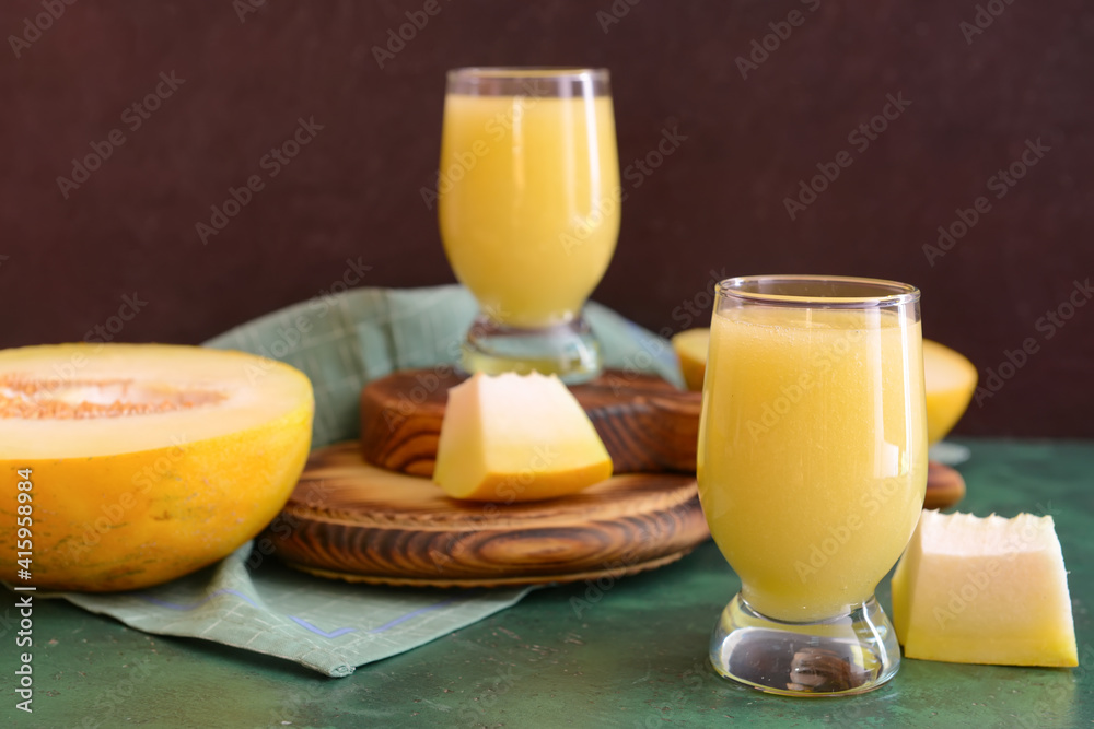 Glasses with melon smoothie on color table