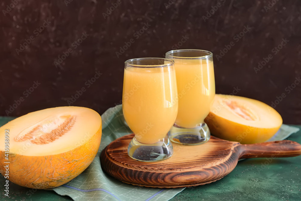 Glasses with melon smoothie on color table