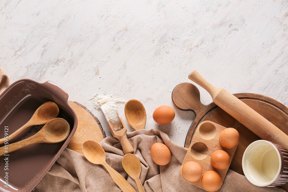 Set of kitchen utensils and ingredients for preparing bakery on light background