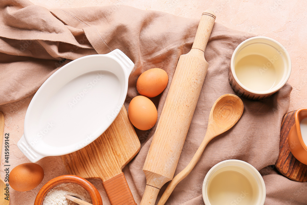 Set of kitchen utensils and ingredients for preparing bakery on color background, closeup