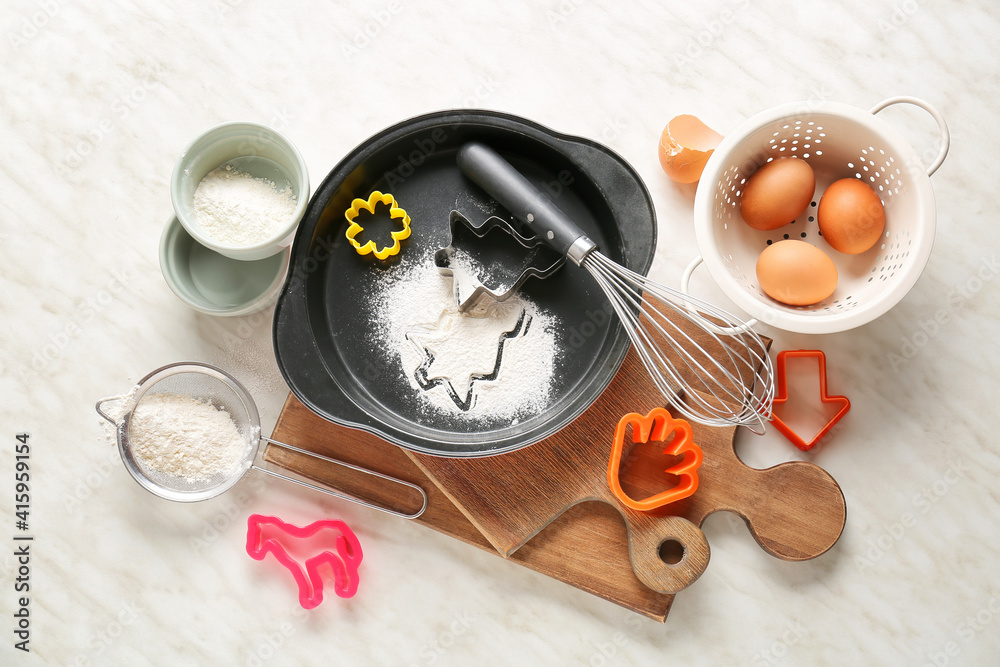 Set of kitchen utensils and ingredients for preparing bakery on light background