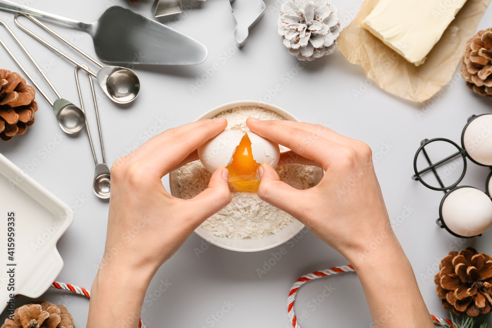 Woman preparing dough on light background