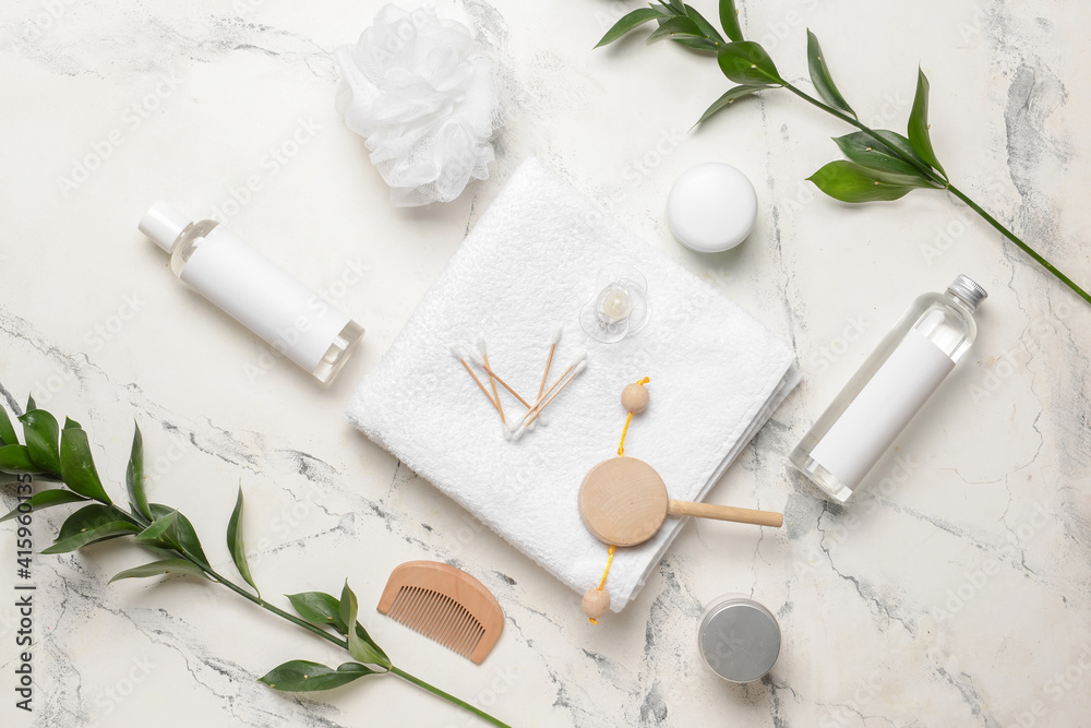 Set of bath accessories for baby and green branches on light background