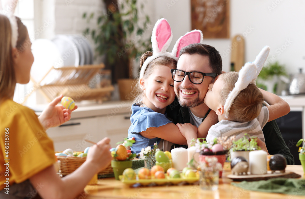 Happy children hugging and kissing father in kitchen