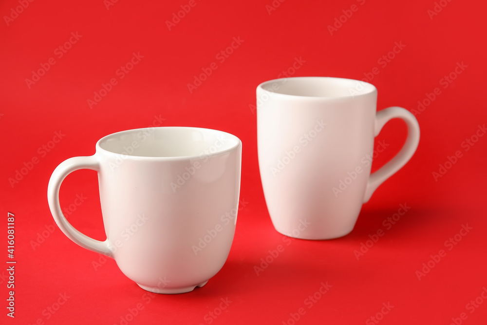 Empty cups on color background