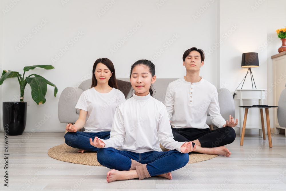 Young Asian family doing exercise together at home