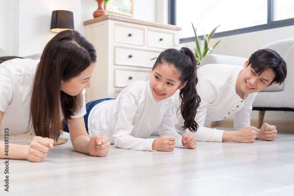 Young Asian family doing exercise together at home