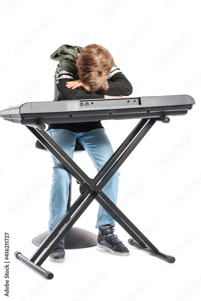 Bored little boy with synthesizer on white background