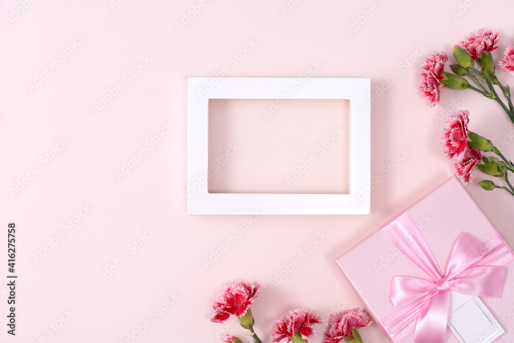 Concept of Mothers day holiday greeting with carnations bouquet on pink background