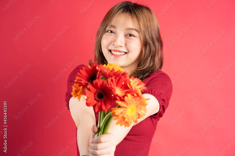 年轻女孩手持非洲菊花束，背景上表情欢快