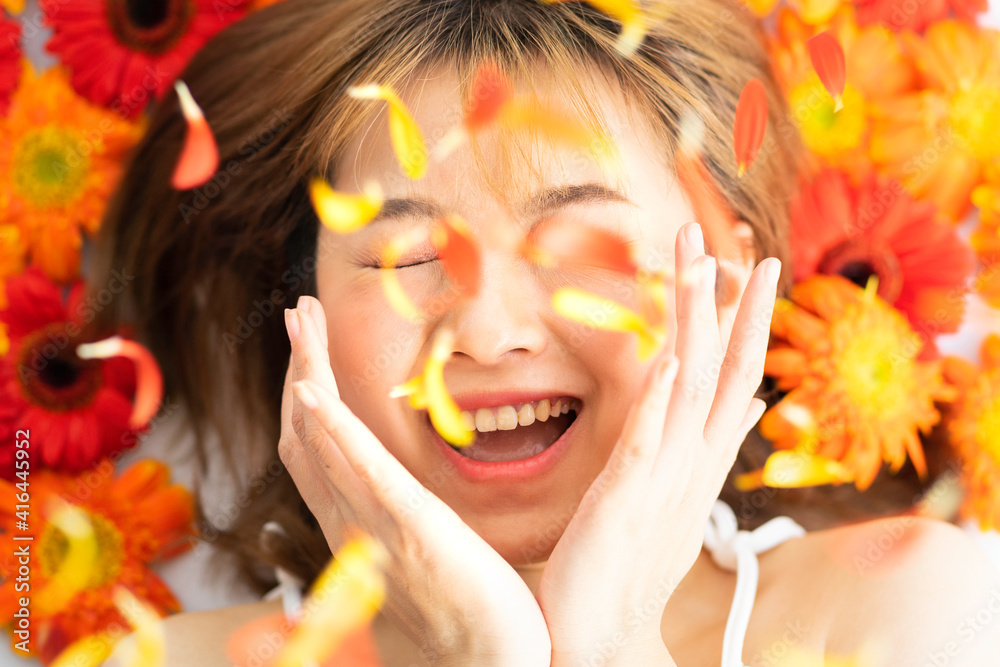 Young girl lying on a flower with a happy expression