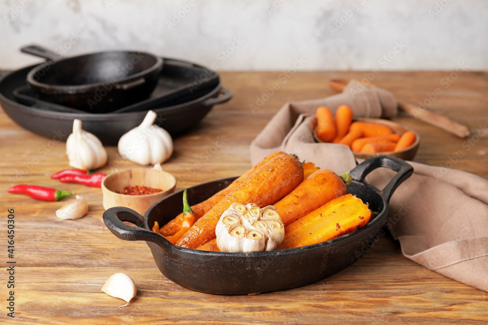 Dish of tasty baked carrot on wooden background