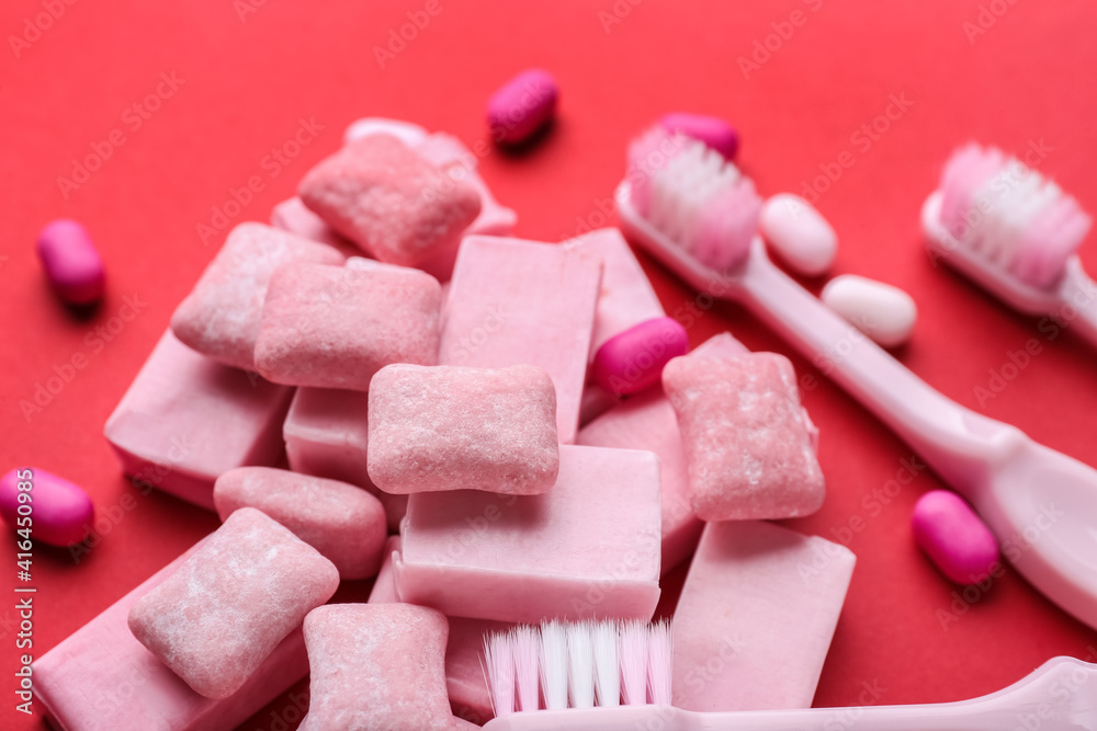 Chewing gums and toothbrushes on color background