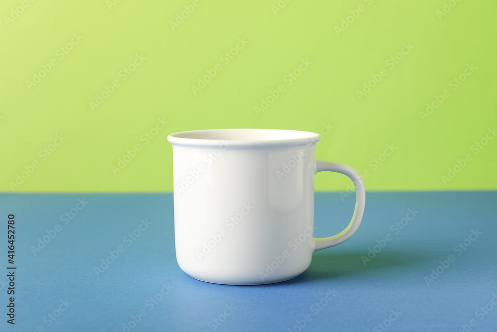 Empty cup on color background