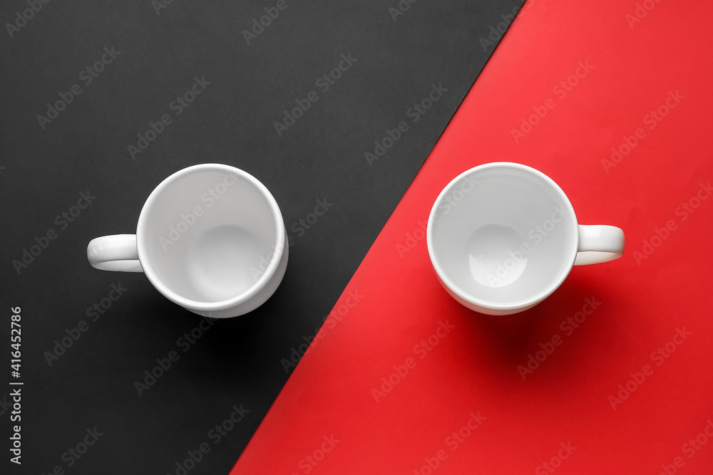 Empty cups on color background