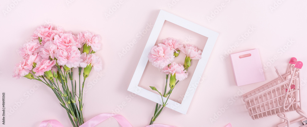 Concept of Mothers day holiday greeting with carnation bouquet on pink background