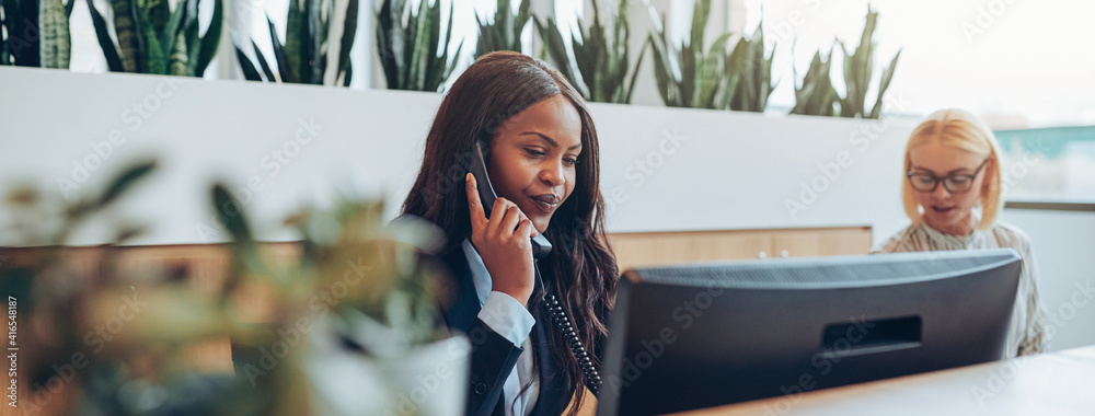 Young African American businesswomen talking on an office telephone