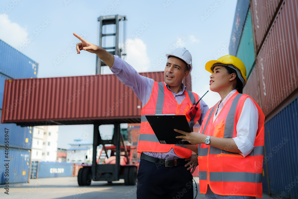 Asian female worker is explaining a check list of container inspections to the supervisor in contain