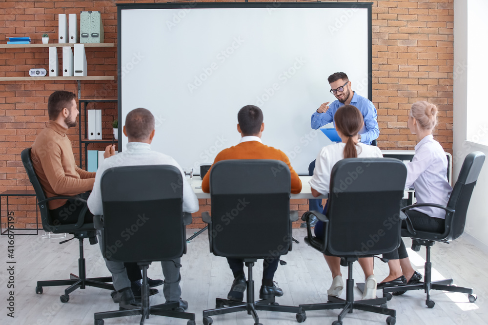 Businessman giving presentation during meeting in office