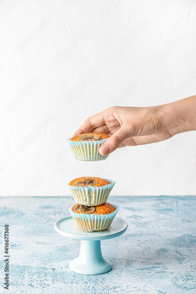 彩色餐桌上有美味香蕉松饼的女性手