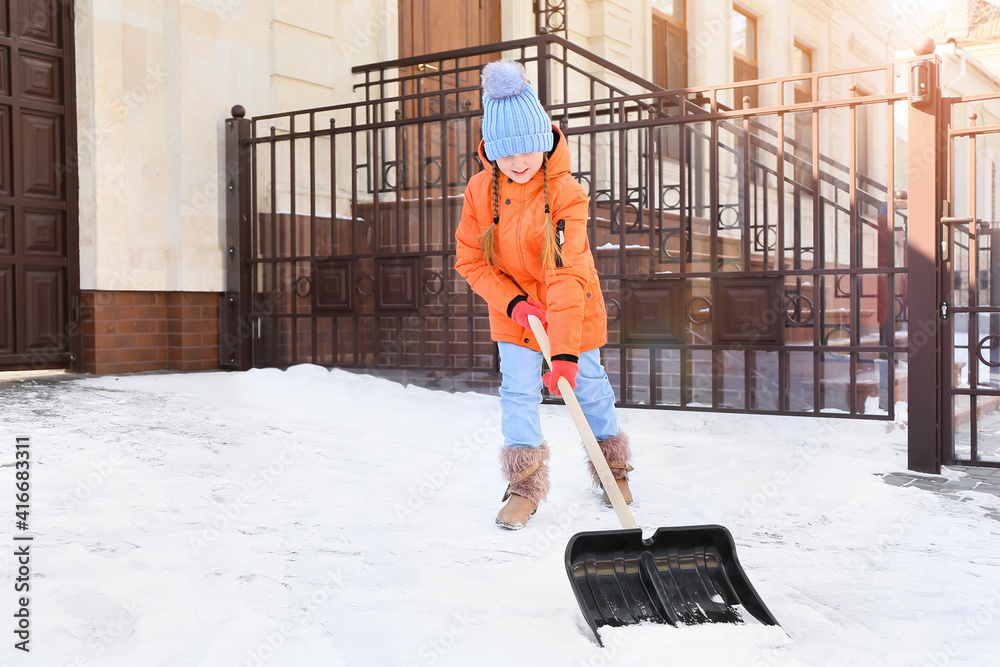 小女孩冬天在户外除雪