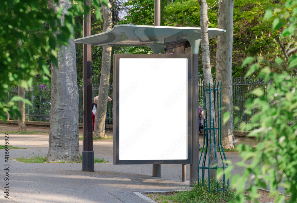 Bus stop billboard Mockup in empty street in Paris. Parisian hoarding advertisement close to a park 