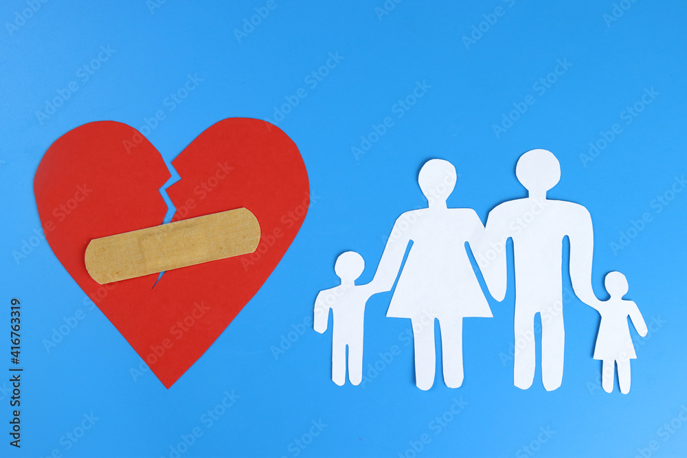 family made of paper and the heart is sealed with a Band-Aid. The concept of divorce, family preserv