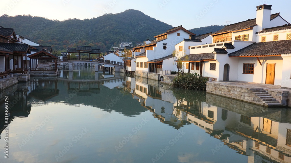 河流两岸的复古建筑和水中倒影的桥梁，中国水上别墅