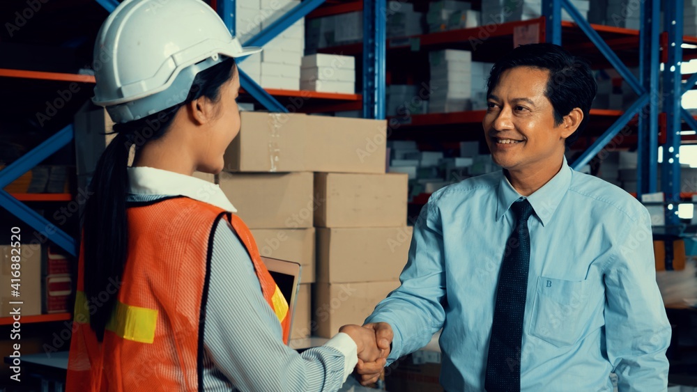 Warehouse manager and worker working in the storehouse . Logistics , supply chain and warehouse busi