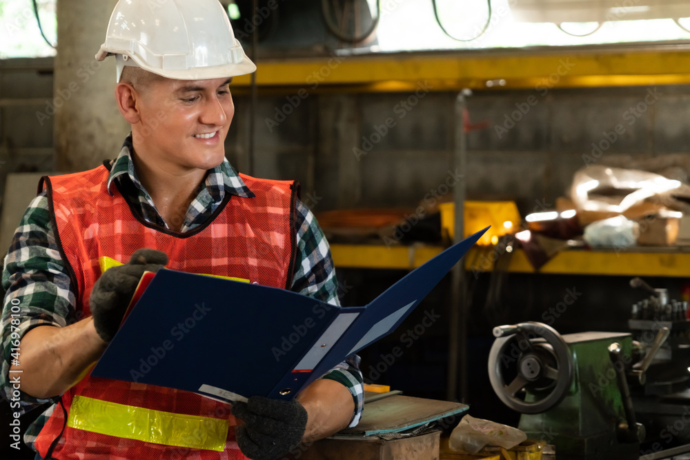 Manufacturing worker working with clipboard to do job procedure checklist . Factory production line 