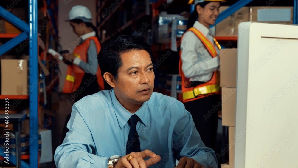 Warehouse manager and worker working in the storehouse . Logistics , supply chain and warehouse busi