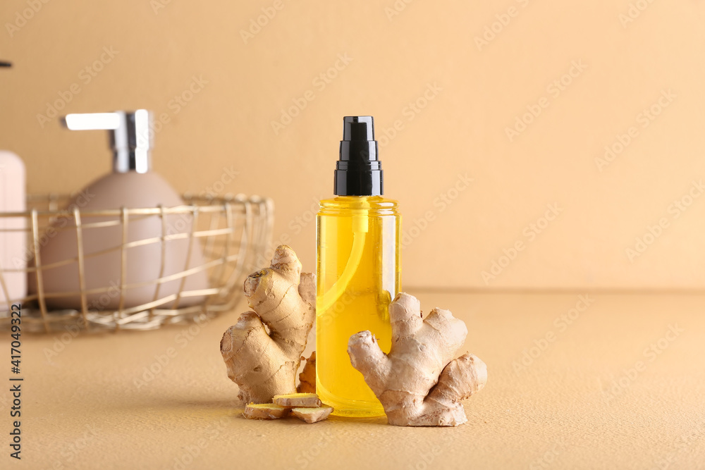 Bottle with ginger essential oil on color background