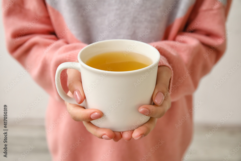 拿着一杯热茶的女人，特写