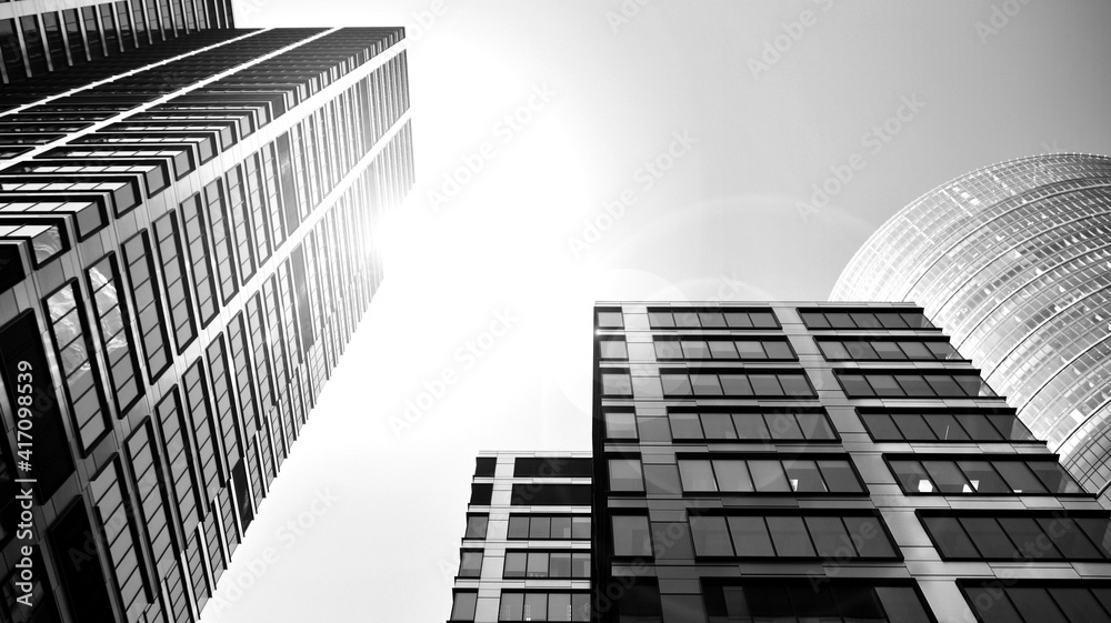 Bottom view of modern skyscrapers in business district against sky. Looking up at business buildings