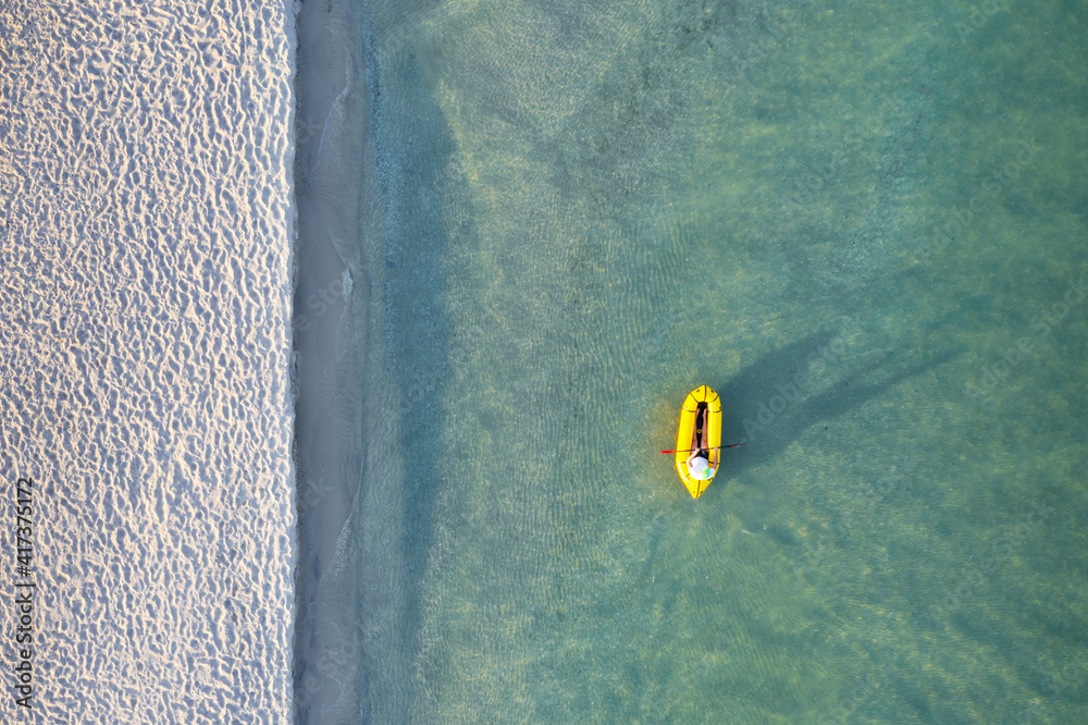 Yellow packraft rubber boat and turquoise water waves from top view. Active travel summer vacations 