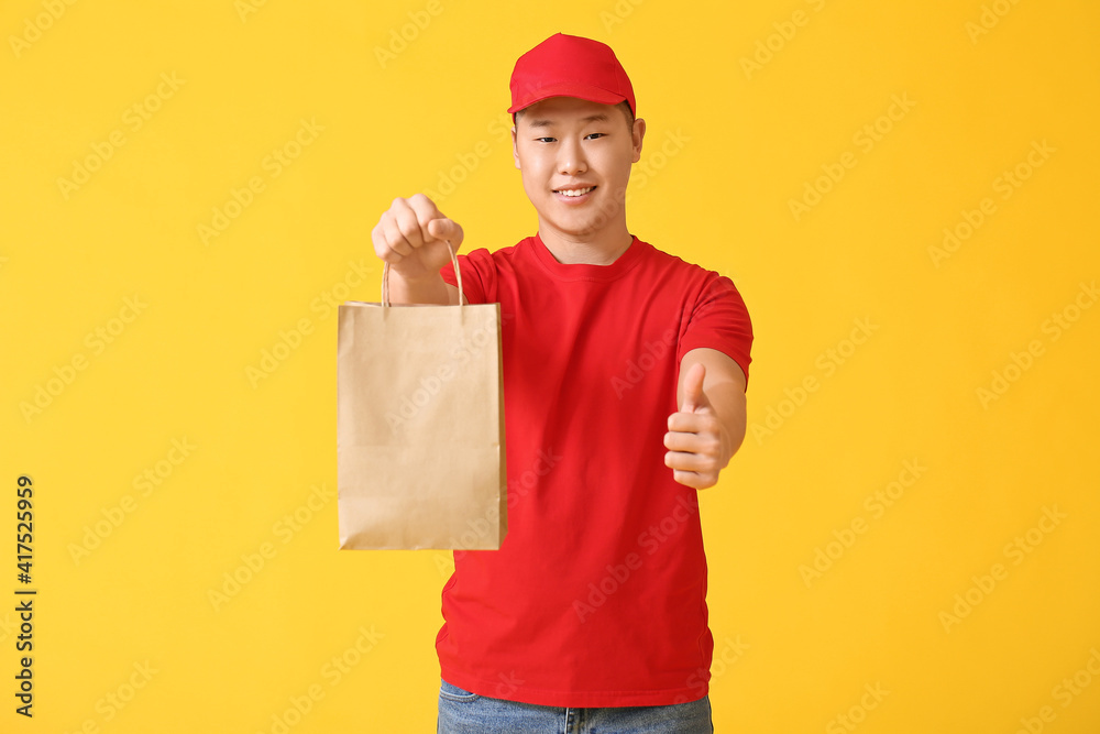 Courier of food delivery service showing thumb-up on color background