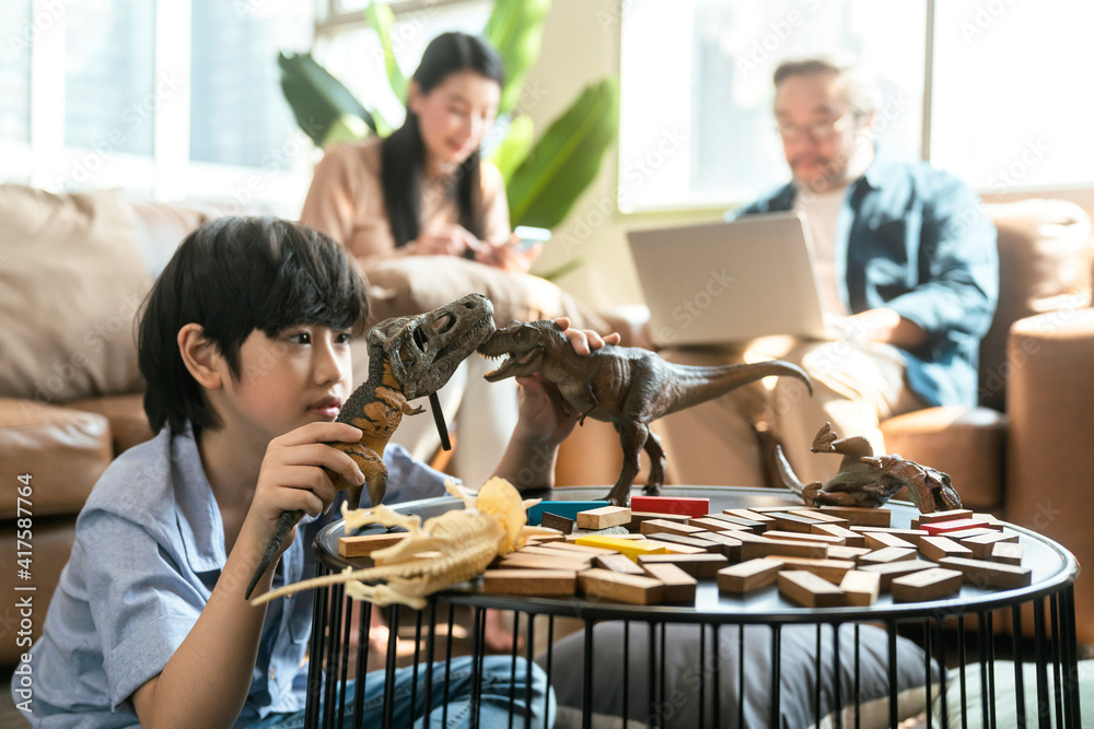 快乐的儿子孩子玩耍，父母一起在家放松沙发，微笑活跃的男孩娱乐