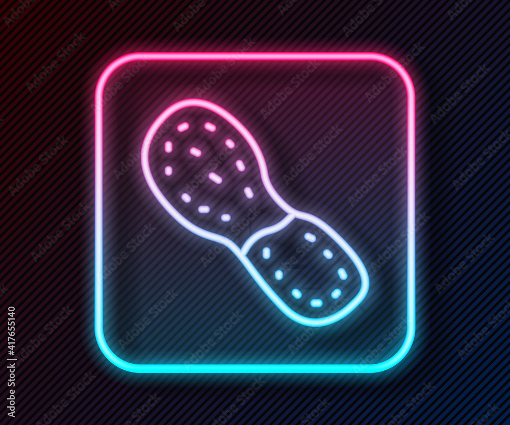 Glowing neon line Human footprints shoes icon isolated on black background. Shoes sole. Vector.