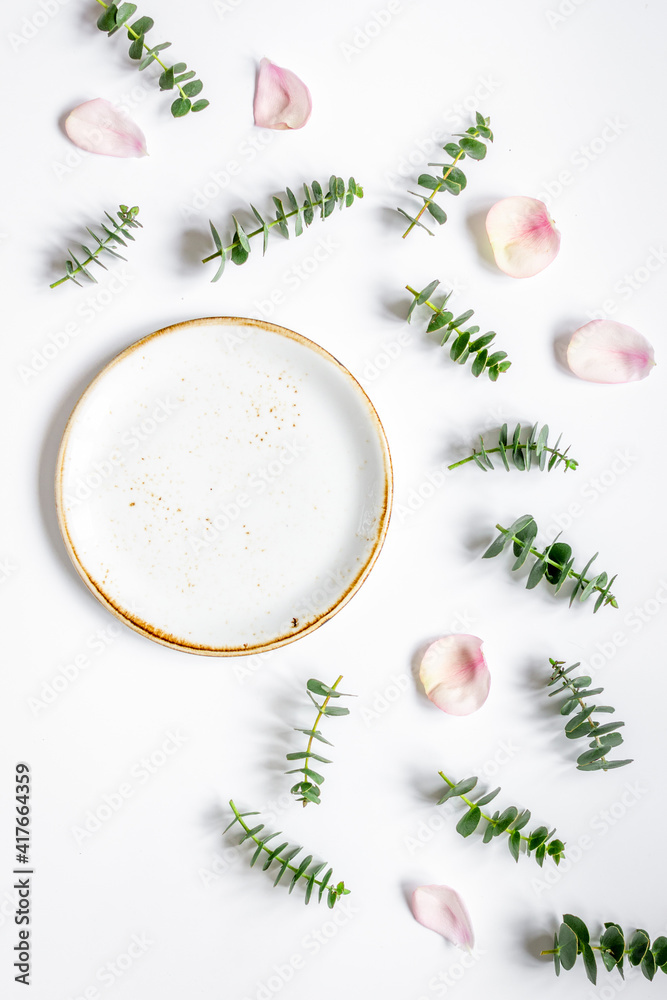 Mock up with rose petals and eucalyptus on white table top view