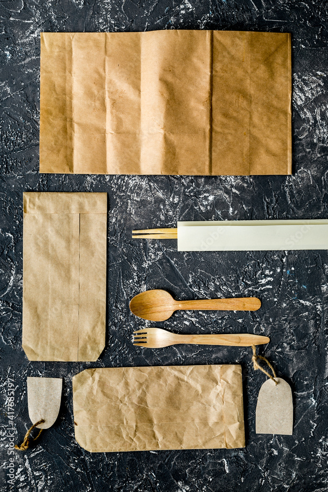 food delivery with paper bags and flatware on gray background top view