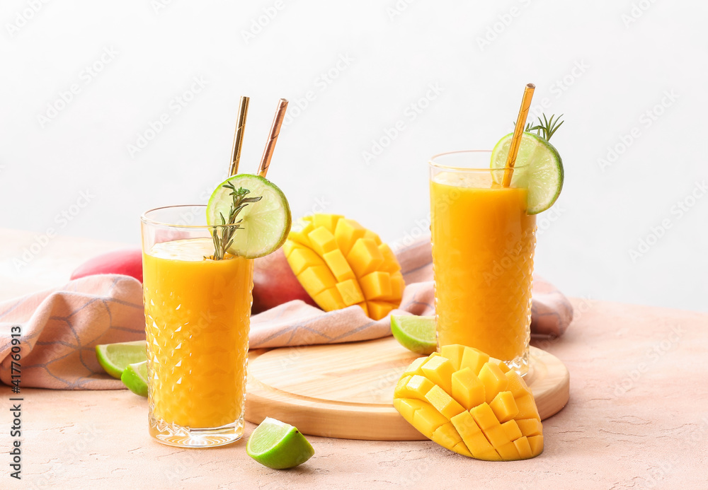 Glasses with tasty mango smoothie on table